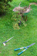 Gardening Tools. Agricultural concept. Farming season. Scissors, saw, wheelbarrow
