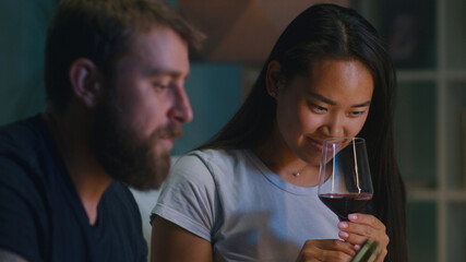 Diverse couple drinking wine in living room