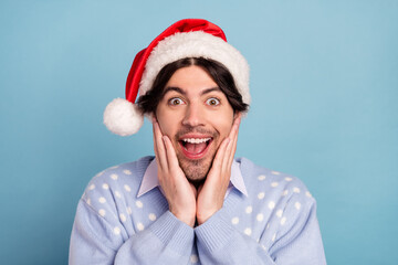 Photo of amazed positive shocked young man hold hands face cheeks holiday isolated on blue color background