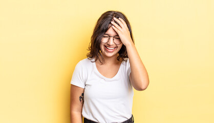 young pretty girl laughing and slapping forehead like saying d’oh! I forgot or that was a stupid...