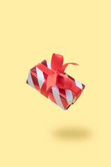 Christmas gift box levitation on warm background. Holiday gift concept.
