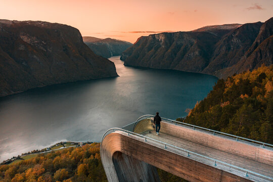 A Tourist Views Aurlandsfjord From the Stegastein Lookout in Norway at Sunset