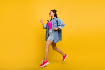 Full length profile side photo of young black girl happy positive smile jump go run hurry isolated over yellow color background