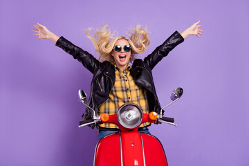 Fototapeta na wymiar Portrait of attractive cheerful crazy wavy-haired girl riding moped having fun isolated over bright violet purple color background