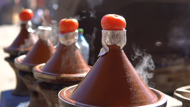  traditional moroccan tajine food cooking in tajine pots on the fire with smoke