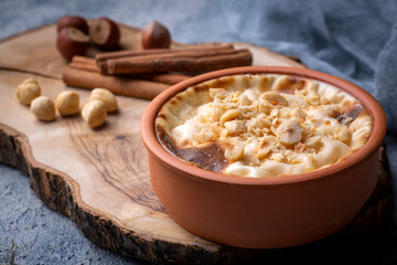 Baked rice pudding turkish milky dessert sutlac in earthenware casserole with hazelnuts