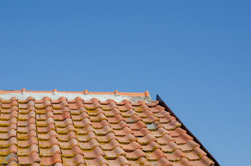 House: building with pitched roof with brick tiles, visible the upper pitch line, ridge tiles and steel front.