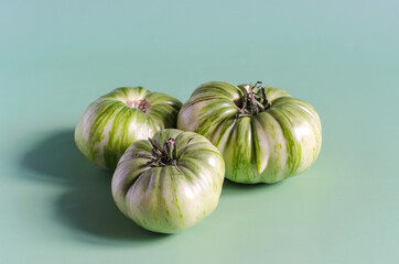 Green tomatoes on a light green background of the mine space. Large green tomatoes close up	