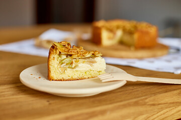 Piece of apple or pear pie, tart with caramel nuts on wooden table, copy space, top view.