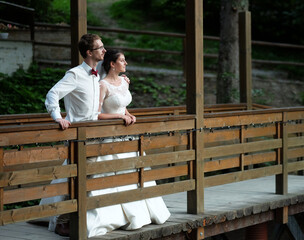 A young bride and groom standing together and hug outdoor