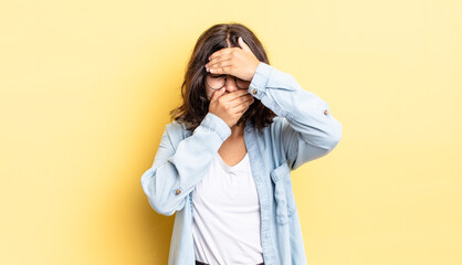 young pretty girl covering face with both hands saying no to the camera! refusing pictures or...