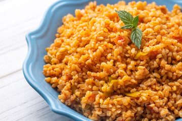 Traditional turkish bulgur pilaf with tomato sause in plate (Turkish name; meyhane pilavi)