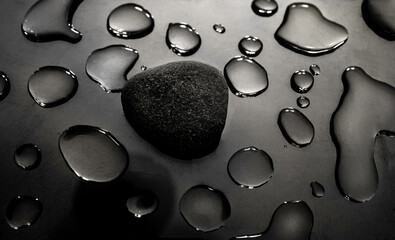 Waterdrops and a stone on reflective gray background. Abstract shapes of crystal clear waterdrops...