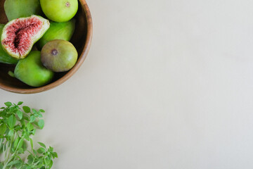 Juicy and ripe pear-shaped figs lie on a plate and cut against a light background.
