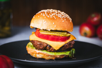Classic burger with all ingredients on a charcoal grill