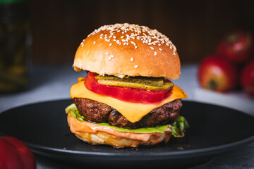 Classic burger with all ingredients on a charcoal grill