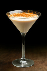 Appetizing banana and cream cocktail against black background.
