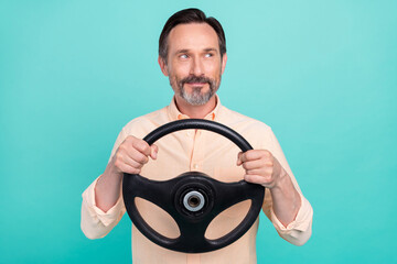 Photo of nice age man drive look empty space wear peach shirt isolated on teal color background