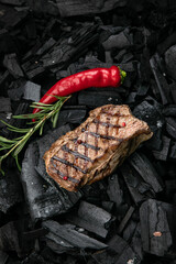 grilled steak on a background of black charcoal.
