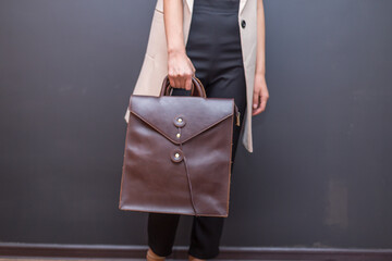 Brown leather bag in the hand on a woman