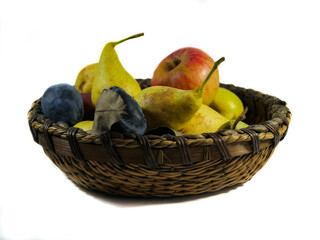 Home growth riped fruits , pear, apple and plum in a wooden bowl isolated on white background.
