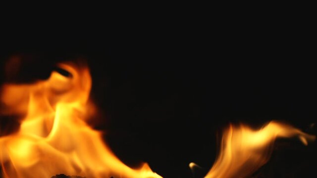 Fire and flames from burning rubber on dark background. Heat footage for templates and alpha channel editing pattern. Empty copy space for text, title or logo design. Place for ads in loop of fire.