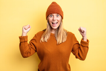 blonde pretty woman feeling happy, positive and successful, celebrating victory, achievements or...