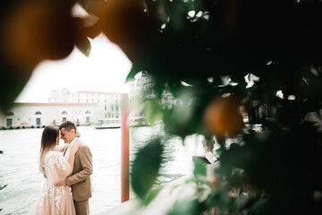 Gorgeous happy couple standing close to each other and looking in eyes in Venice, Italy