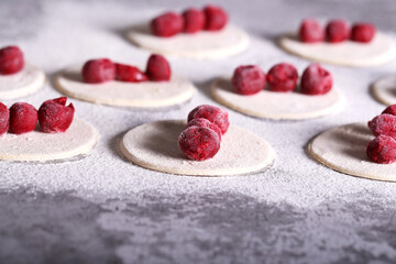 dumplings with cherries are prepared on the table