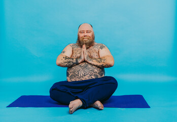 Funny fat man doing yoga meditation