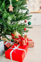 christmas tree with colorful balls and gift boxes on white kitchen background
