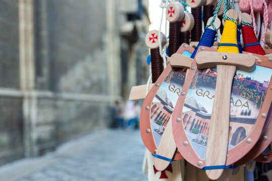 Exhibition of toys, with shields and swords, displayed on an outdoor shop in Granada, Andalusia, Spain. Blurred background. Selective focus.