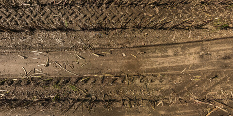 panorama of road from above on surface of gravel road with car tire tracks