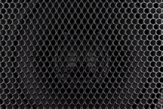 Stylish car audio acoustic round speaker with waffle grill protector cover closeup. Modern music black background texture