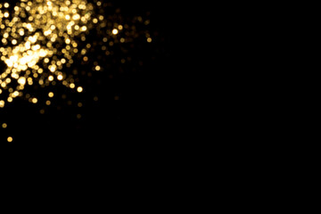 Golden blurred bokeh lights on black background. Glitter sparkle stars for celebrate. Overlay for...