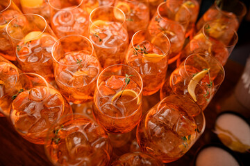 angle view of glasses of aperol spritz cocktail with ice cubes and orange slices