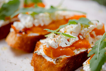 grilled ciabatta bruschetta with baked pumpkin, feta arugula and spices. healthy fall baked pumpkin snack