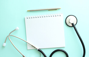 White notepad and stethoscope on a blue background.