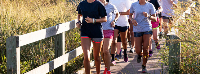Girls running on boardwalk surrounded by merium grass on Fire Island