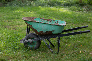 Old green wheelbarrow in the garden