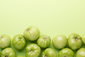 Green tomatoes for conservation on a green background. Unripe tomatoes for harvesting.