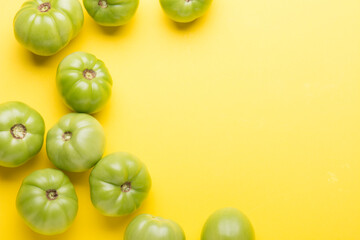 Green tomatoes for conservation on a yellow background. Unripe tomatoes for harvesting.