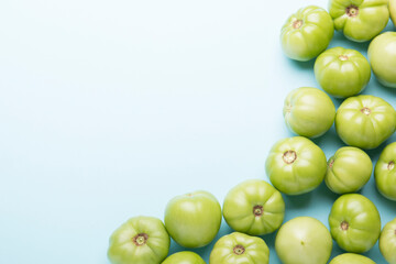 Green tomatoes for conservation on a blue background. Unripe tomatoes for harvesting.