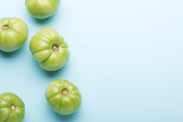 Green tomatoes for conservation on a blue background. Unripe tomatoes for harvesting.
