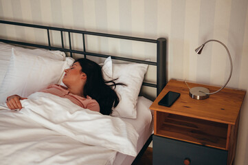Young gorgeous woman lying in her bed in the morning