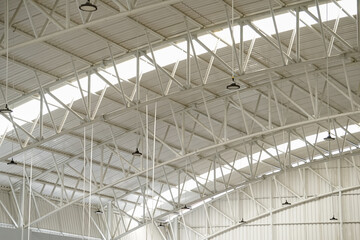 a steel roof in a giant building. a high white roof that is most suitable for industrial buildings. a giant construction with iron material.