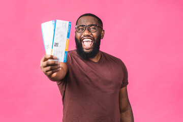 Young African american black Man Holding Boarding Pass tickets isolated Over pink Background.