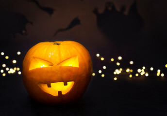 Pumpkin with glowing eyes on a black background with defocused lights