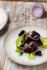 Roasted red meat shashlik on a plate with green salad in a restaurant