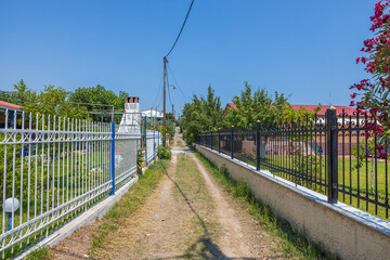 Beautiful landscape view of typical village street and on road with a metal fence on both sides.  Greece.